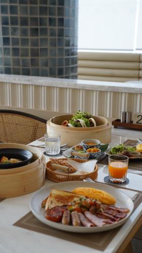 a table with a plate of food on a table at Arco Phuket Town in Phuket Town