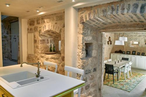 a kitchen and dining room with a stone wall at Waterfront Historical Villa Perast in Perast