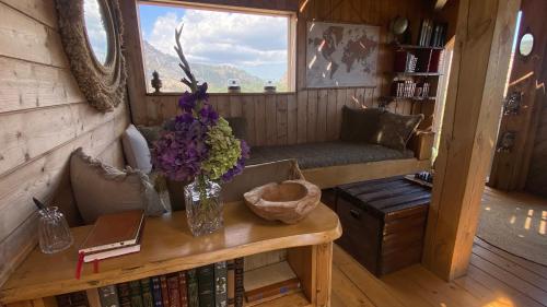 une pièce avec une table avec un vase de fleurs dessus dans l'établissement Cocoon Village, à Porto-Vecchio