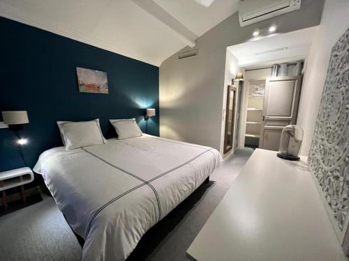 - une chambre avec un lit blanc et un mur bleu dans l'établissement Villa Solenzaïa, à Grimaud