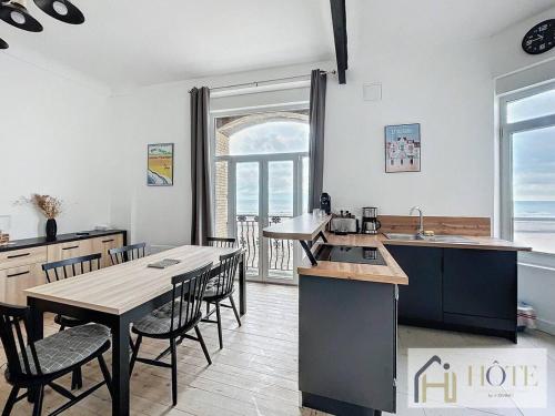 une cuisine et une salle à manger avec une table et des chaises dans l'établissement Elégance Marine - 2 CH Vue Mer, à Bray-Dunes