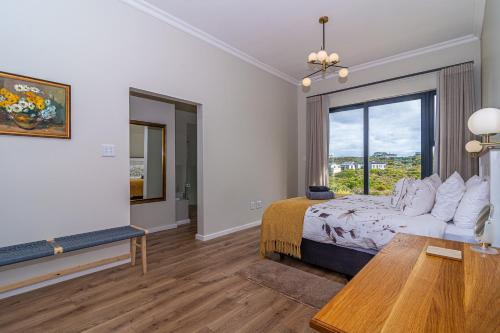 a bedroom with a bed and a large window at Lighthouse Villa Romansbaai in Gansbaai