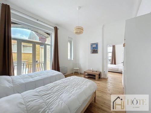 une chambre avec deux lits et une grande fenêtre dans l'établissement Elégance Marine - 2 CH Vue Mer, à Bray-Dunes