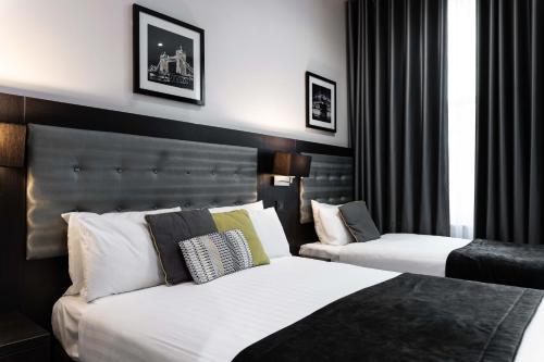 a hotel room with two beds and a window at The W14 Kensington in London