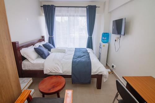 a small bedroom with a bed and a window at Miiza Realtors in Nairobi