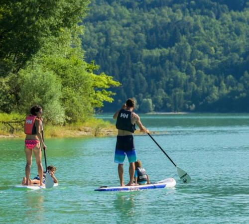 a group of people on a paddle board in the water at L'Atelier du Peintre in Clairvaux-les-Lacs