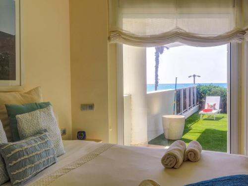 Un dormitorio con un gran ventanal con vista al mar. en Luxury Seaview Apartment by Hello Homes Sitges, en Sitges