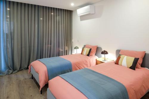 two beds sitting in a room with curtains at Casa do Colhereiro with Private Pool in Luz de Tavira in Luz de Tavira