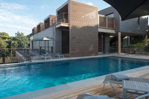 a swimming pool in front of a house at Le Tomino in Macinaggio