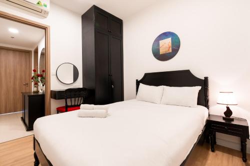 a bedroom with a large white bed and a mirror at Otis Soho Saigon Balcony Apartment in Ho Chi Minh City