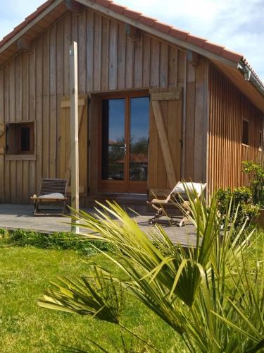 une maison en bois avec une grande porte en verre dans l'établissement Cabane et jardinet, à Magescq
