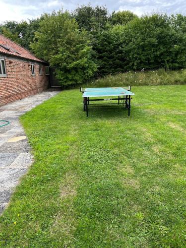a picnic table in the grass in a yard at Low Farm Barn, a family and dog friendly haven in Brundish