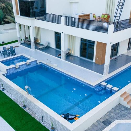 a swimming pool in front of a house at استراحة دار الضباب Dar ALDhabab in Ḑibāb