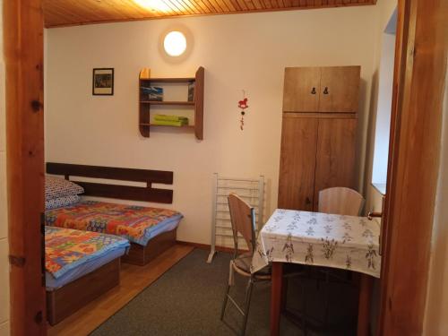 a room with a table and a bed and a table and chairs at Apartmán Margarétka in Liptovský Trnovec