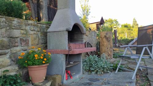 a stone oven with a flower pot and a plant at Apartmán Margarétka in Liptovský Trnovec