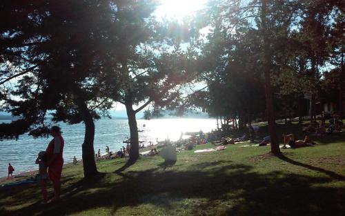 a group of people sitting on the beach near the water at Apartmán Margarétka in Liptovský Trnovec