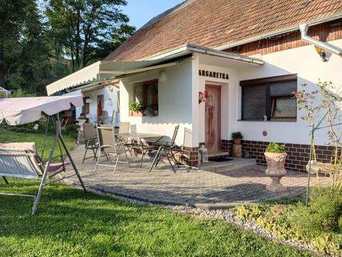 a house with a patio and a table and chairs at Apartmán Margarétka in Liptovský Trnovec