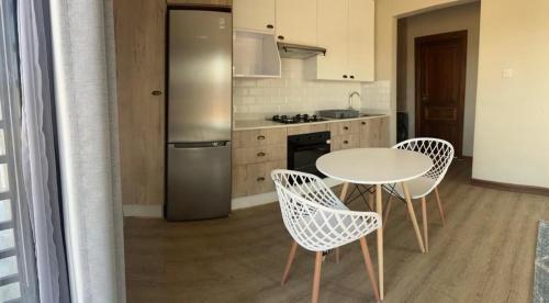 a kitchen with a table and chairs and a refrigerator at charming retreat in Gaborone