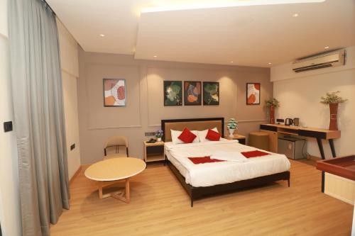 a bedroom with a bed and a table and a desk at Sri Vishnu Inn in Bengaluru