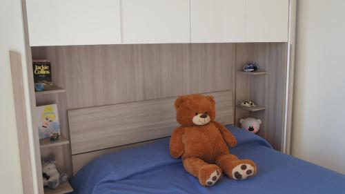 a teddy bear sitting on top of a bed at Villa San Martino in Cellino Attanasio
