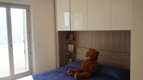 a teddy bear sitting on top of a bed at Villa San Martino in Cellino Attanasio