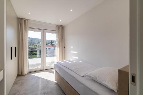 a bedroom with a bed and a large window at Bracera Luxury Apartments in Slatine