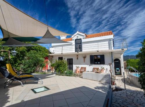 a house with a patio in front of it at Rustic Villa Rudine in Dobrinj