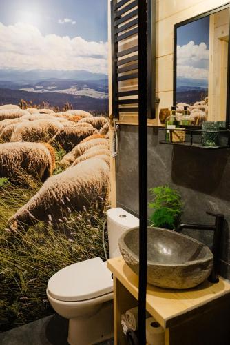 a bathroom with a sink and a herd of sheep at Sopki Stopki Polana Wspólna in Cięcina
