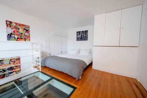 une chambre avec un lit et une table en verre dans l'établissement Cozy Artist Loft, à Paris