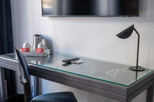 a glass desk with a lamp on top of it at Hotel Mademoiselle in Paris