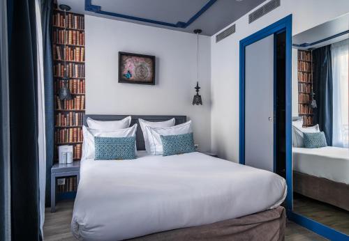 a bedroom with a white bed with a blue door at Hotel Mademoiselle in Paris