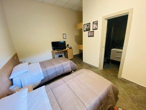 a hotel room with two beds and a television at B&B l'angoletto in Trebisacce
