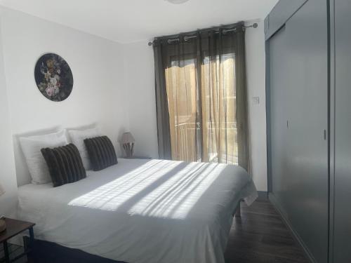 une chambre avec un lit blanc et une fenêtre dans l'établissement place Peyramale, à Lourdes