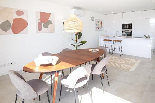 a kitchen and dining room with a wooden table and chairs at Casa do Colhereiro with Private Pool in Luz de Tavira in Luz de Tavira