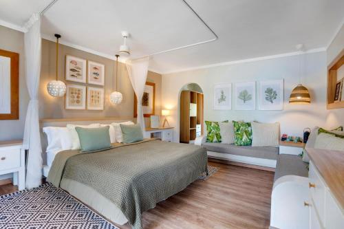 a bedroom with a large bed and a couch at Indian Ocean Lodge in Grand'Anse Praslin