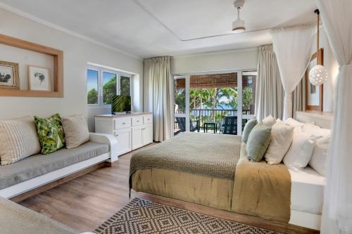 a bedroom with a bed and a couch at Indian Ocean Lodge in Grand'Anse Praslin