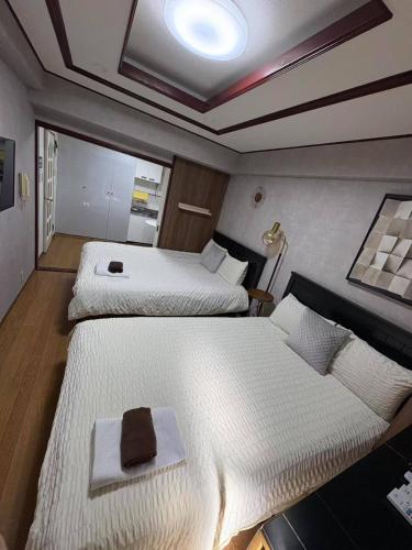 two beds in a small room with at 日韓マンション in Tokyo