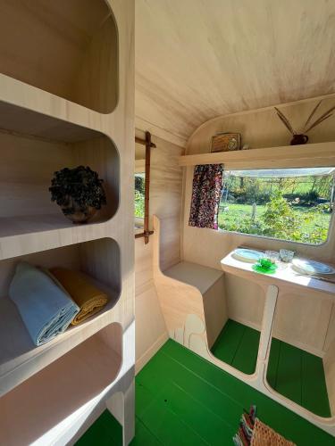 Cette petite chambre dispose d'une fenêtre et d'un sol vert. dans l'établissement Camping Les Ronds Duval face aux îles anglo-normandes, à Les Moitiers-dʼAllonne