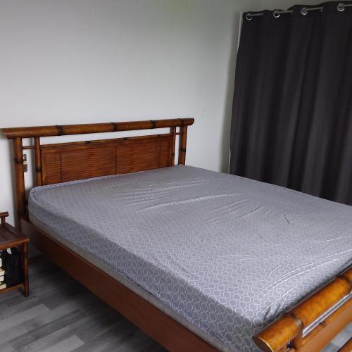 - un lit dans une chambre dotée d'un rideau noir dans l'établissement Maison de campagne, à Saint-Martin-des-Noyers