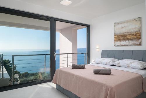 une chambre avec un lit avec vue sur l'océan dans l'établissement Luxury Villa Ivana Brela heated pool 28 m2, gym, à Brela