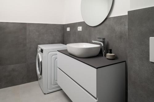 une salle de bain avec un lavabo et une machine à laver dans l'établissement Luxury Villa Ivana Brela heated pool 28 m2, gym, à Brela