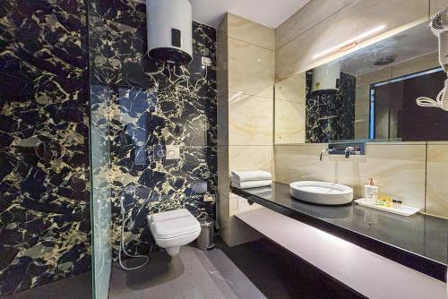 a bathroom with a toilet and a sink at AH Grand Villa - Hotel Near Dalai Lama Temple in McLeod Ganj