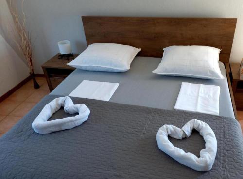 a bed with two heart shaped towels on it at Pansion Stones Murter in Murter