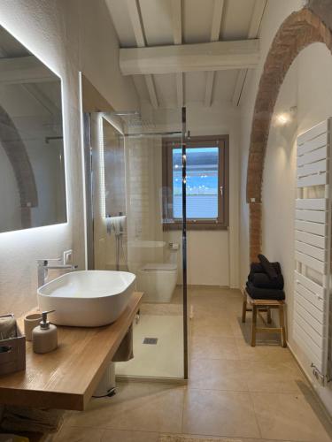 a bathroom with a large white tub and a sink at Casa Leoni Chianni - tuscan luxurious Villa in Chianni