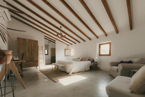 a bedroom with a bed and a desk and a couch at Casa Mona, Turismo de Interior in Llubí
