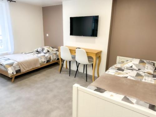 a bedroom with a table and two chairs and a bed at Studio B4 - Centre-Ville Meaux - Proche Disneyland in Meaux
