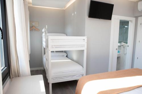 a bedroom with a bunk bed and a white bunk room at Hostal Rosario Galindo in Cúllar-Vega