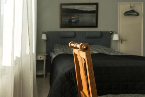 a bedroom with a bed and a wooden chair at Photoeverhome in Bengtsfors