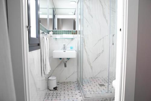 a white bathroom with a sink and a shower at Hostal Rosario Galindo in Cúllar-Vega