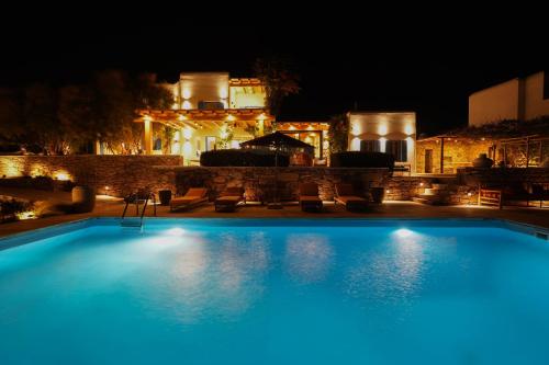 a large swimming pool in front of a house at night at Villa Zina Sunset View St Lazaros 7 plus 1 Bedroom in Psarou